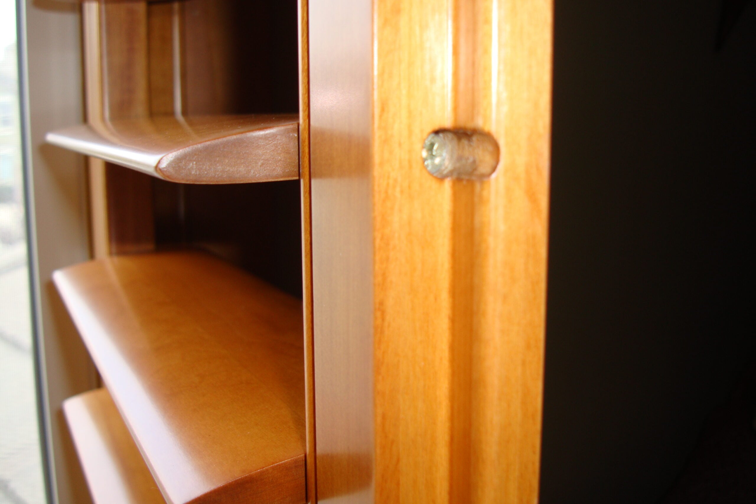 Close-up of stained wood plantation shutter louvers and tilt rod